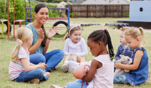 Teacher spending time outside with preschool children